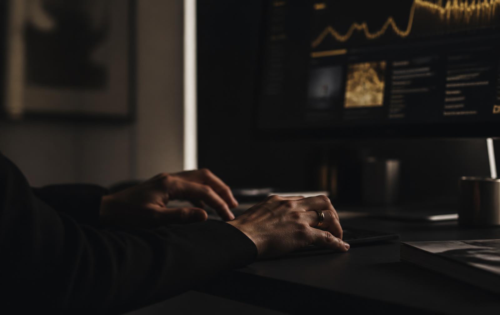 Hands working at a workstation reviewing performance information